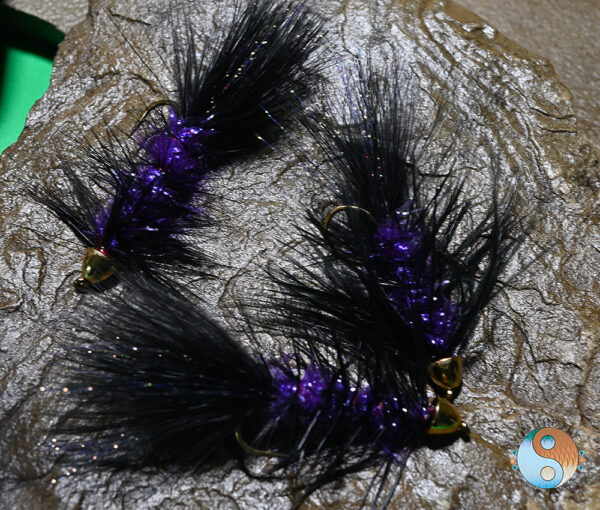 Black Purple Flash Wooly Bugger is a Great Leech Imitation Black Purple Flash Wooly Bugger is tied on a a Dai Riki #4 4XL Hook with long Purple Chenille, Mixed Black and Purple Krystal Flash in the Tail.  Head is 1/4 Gold Cone. American Tied